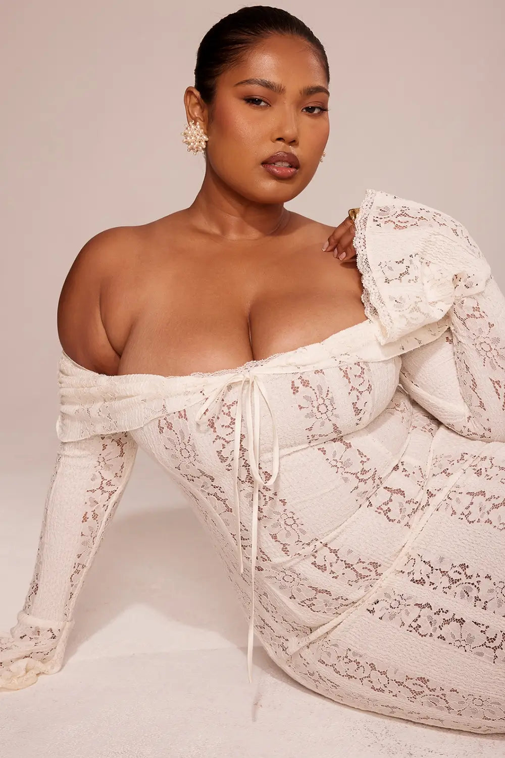 Vestido largo elegante para mujer con encaje floral vintage, diseño off-shoulder con escote corazón, mangas largas y abertura frontal. Ideal como vestido de gala, vestido para boda o vestido de noche sofisticado. El corte favorece la silueta femenina con un estilo romántico y moderno. Perfecto para invitadas de boda, cenas formales y eventos especiales. Vestido con forro completo y acabado premium, perteneciente a la colección edición limitada de Veliara.