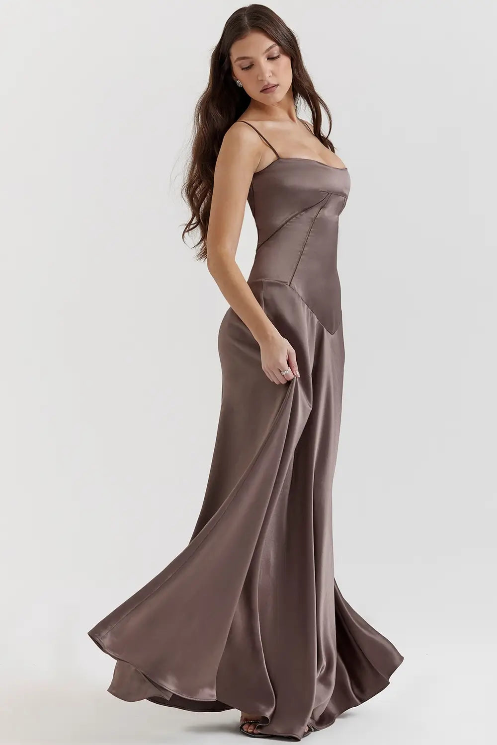 Vestido largo marron elegante para mujer con espalda descubierta y detalle de encaje delicado, ideal para bodas, fiestas formales, cenas especiales y eventos de noche. El modelo Mavie de Veliara está confeccionado en una tela de caída fluida que se adapta al cuerpo con suavidad, realzando la silueta sin apretar. Su escote recto y diseño sin tirantes ofrecen un look sofisticado y sensual, mientras que el encaje en la espalda añade un toque de romanticismo moderno.