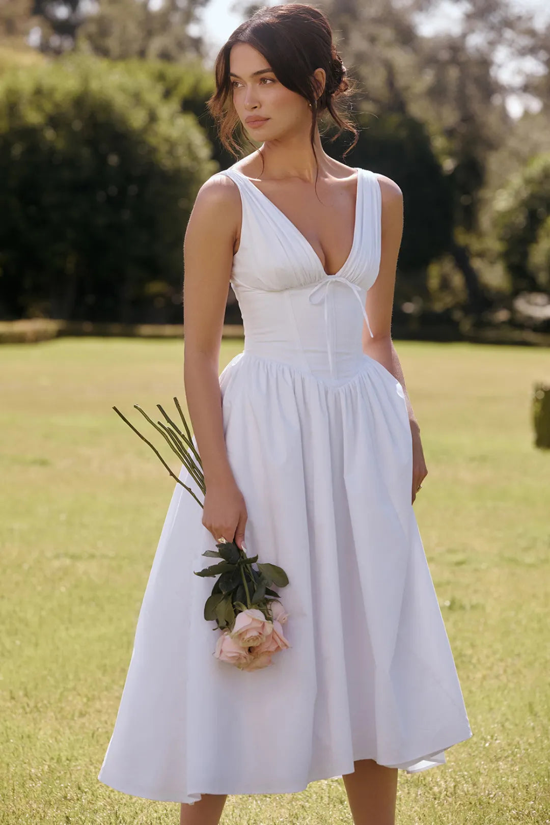 Modelo usando vestido blanco midi con escote profundo y corset – ideal para boda civil