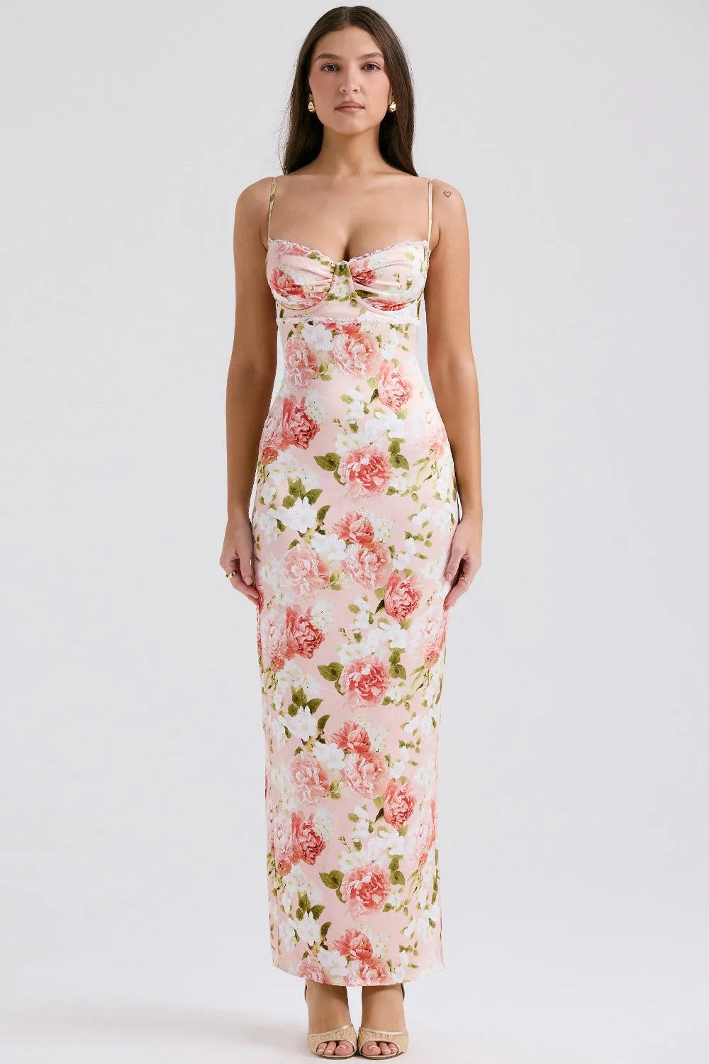 Modelo usando vestido largo floral ajustado al cuerpo con tirantes finos, ideal para fiestas y bodas.