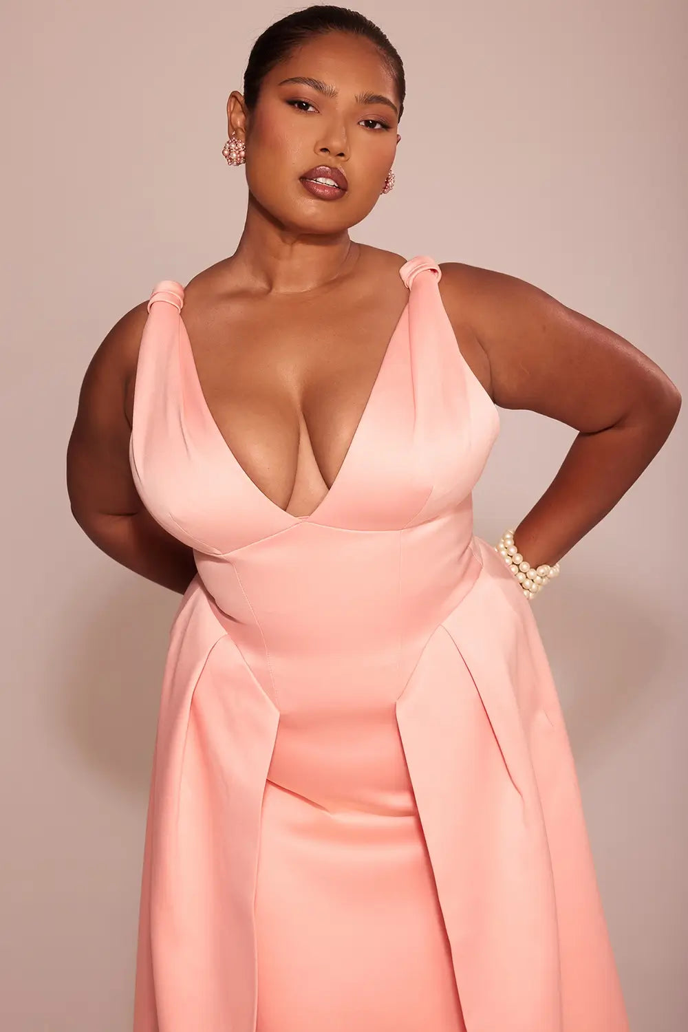 Modelo usando vestido midi rosa de satén plisado – diseño sofisticado con lazos y falda estructurada