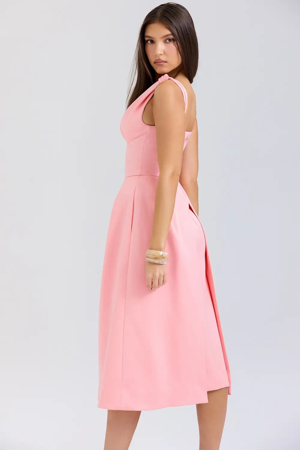 Modelo usando vestido midi rosa de satén plisado – diseño sofisticado con lazos y falda estructurada