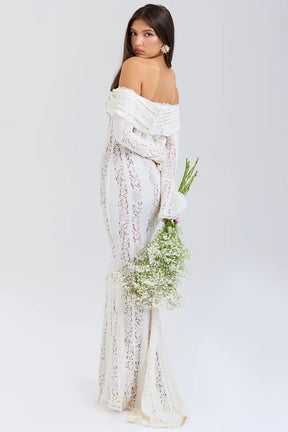 Vestido largo elegante para mujer con encaje floral vintage, diseño off-shoulder con escote corazón, mangas largas y abertura frontal. Ideal como vestido de gala, vestido para boda o vestido de noche sofisticado. El corte favorece la silueta femenina con un estilo romántico y moderno. Perfecto para invitadas de boda, cenas formales y eventos especiales. Vestido con forro completo y acabado premium, perteneciente a la colección edición limitada de Veliara.