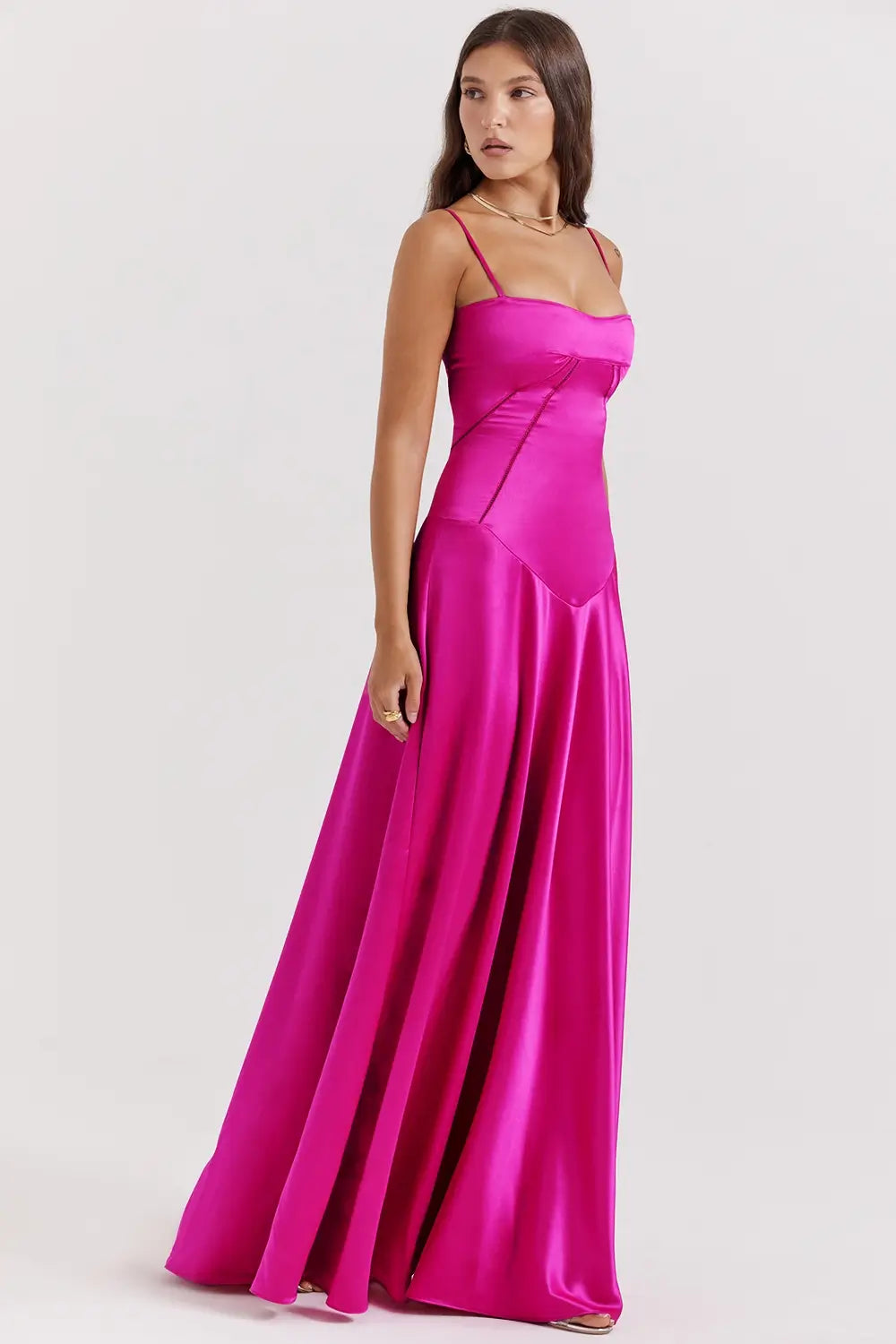 Vestido largo fucsia elegante para mujer con espalda descubierta y detalle de encaje delicado, ideal para bodas, fiestas formales, cenas especiales y eventos de noche. El modelo Mavie de Veliara está confeccionado en una tela de caída fluida que se adapta al cuerpo con suavidad, realzando la silueta sin apretar. Su escote recto y diseño sin tirantes ofrecen un look sofisticado y sensual, mientras que el encaje en la espalda añade un toque de romanticismo moderno.