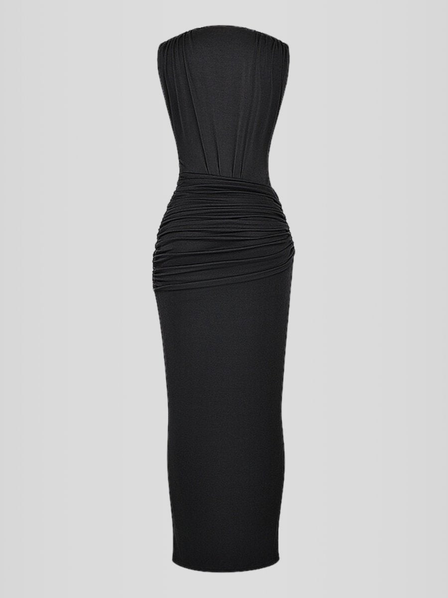 Modelo usando vestido largo negro con escote profundo en V, sin mangas, drapeado frontal y abertura alta en la pierna. Diseño ajustado, elegante y sofisticado.
