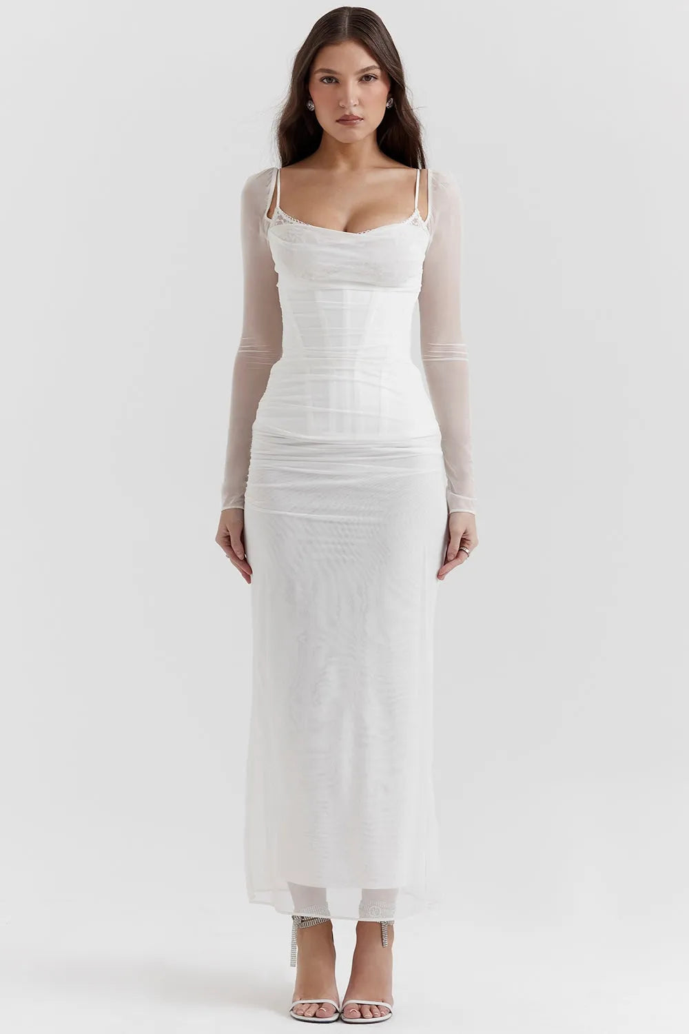 Diseño largo blanco con encaje delicado, corset ajustado y mangas largas. Perfecto para bodas civiles o looks románticos.
