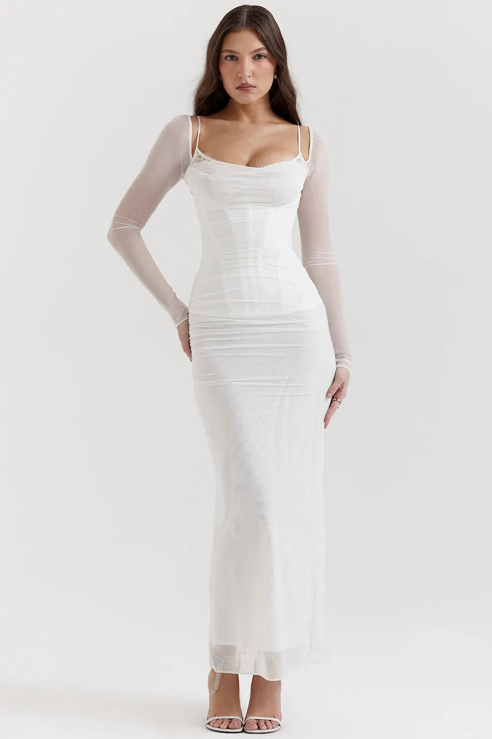 Diseño largo blanco con encaje delicado, corset ajustado y mangas largas. Perfecto para bodas civiles o looks románticos.