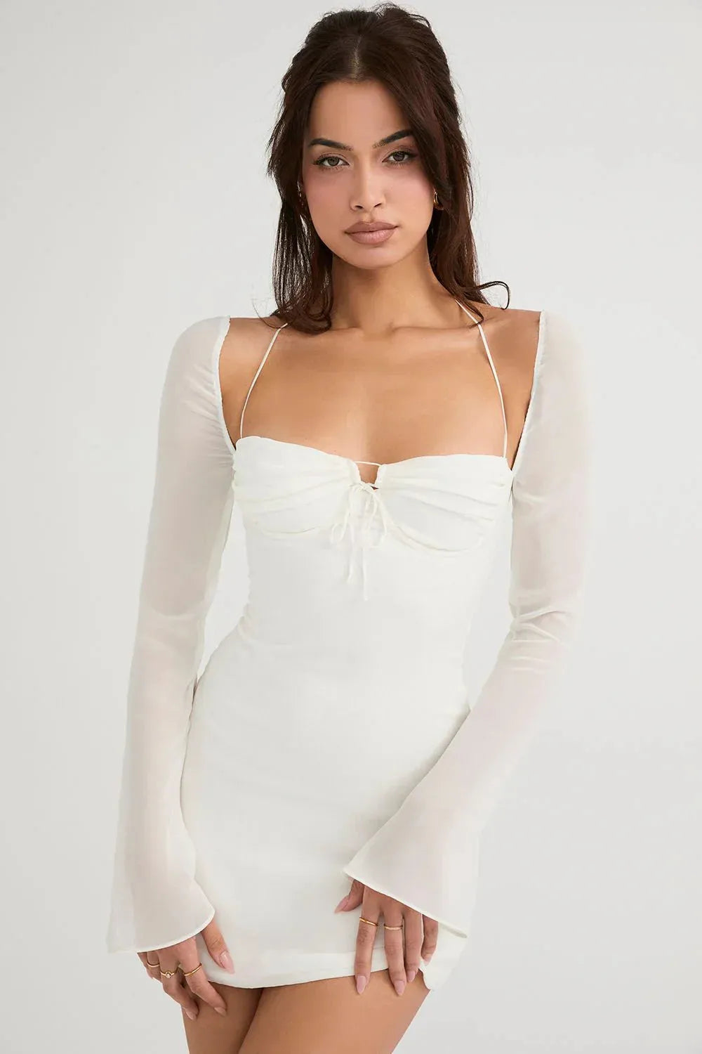 Modelo usando vestido blanco corto Mini Olivia con tirantes finos en jardín elegante