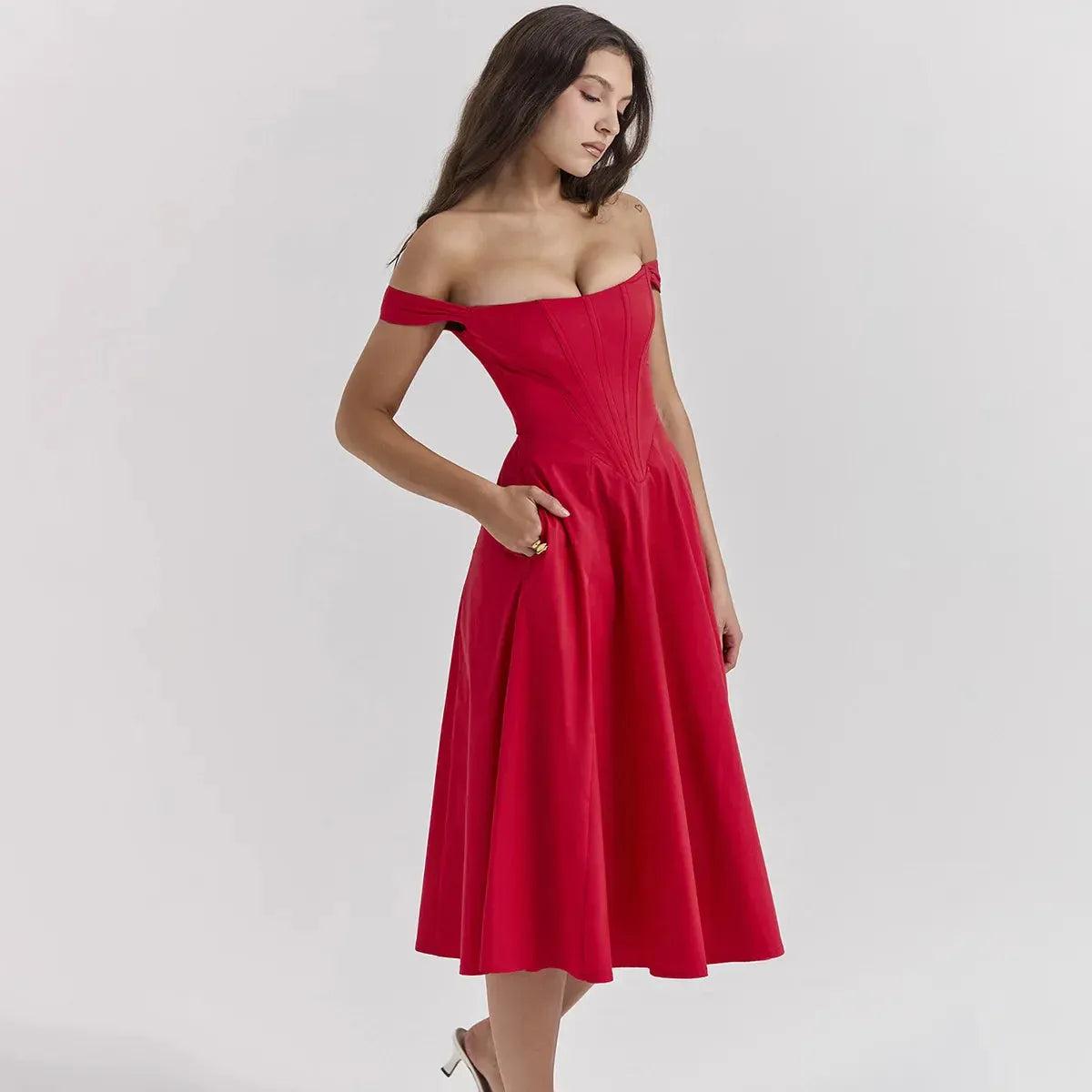 Modelo usando vestido rojo midi con corset y falda amplia, perfecto para graduación o eventos elegantes de noche.