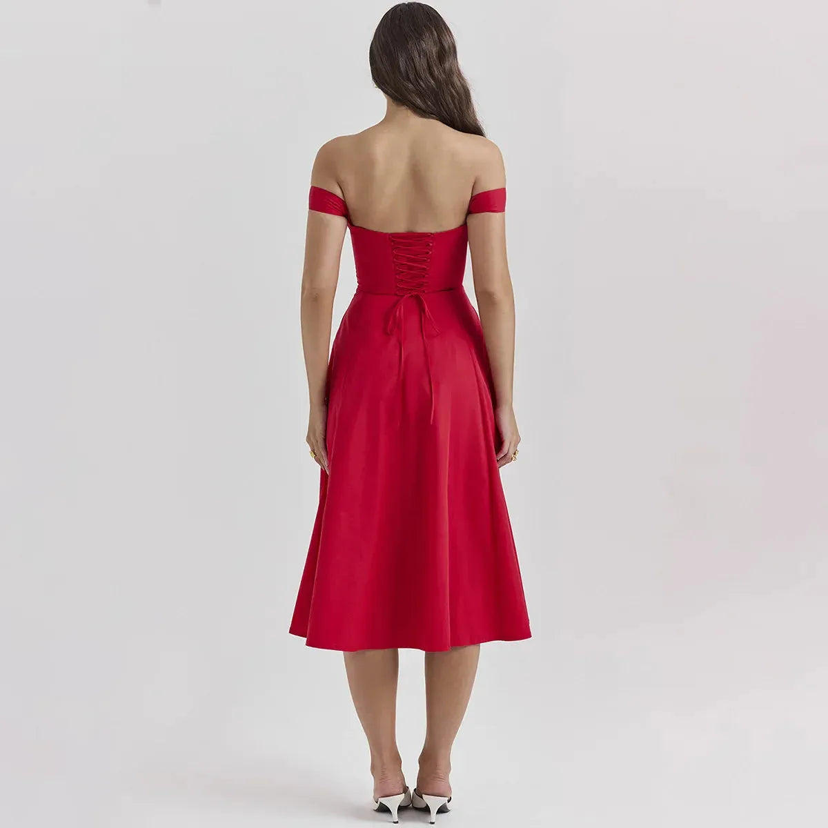 Modelo usando vestido rojo midi con corset y falda amplia, perfecto para graduación o eventos elegantes de noche.