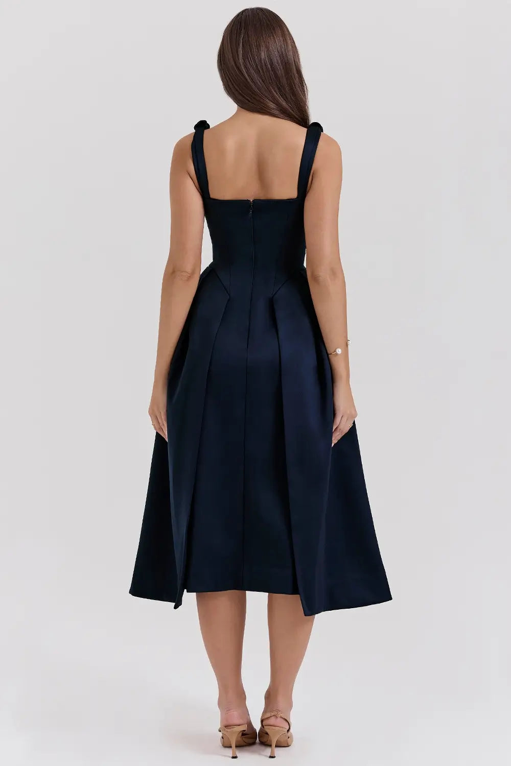 Modelo usando vestido midi plisado de satén azul marino – ideal para bodas y eventos especiales